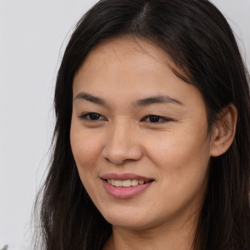 Joyful asian young-adult female with long  brown hair and brown eyes