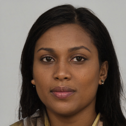 Joyful black young-adult female with long  brown hair and brown eyes