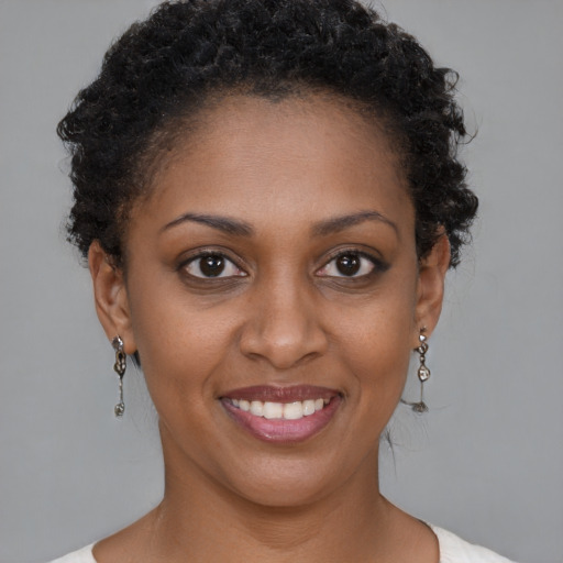 Joyful black young-adult female with short  brown hair and brown eyes