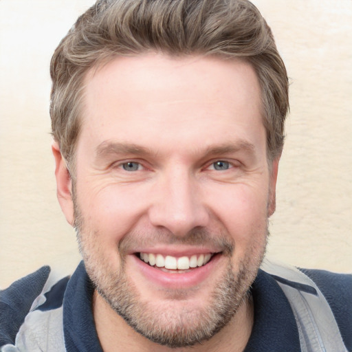 Joyful white adult male with short  brown hair and grey eyes