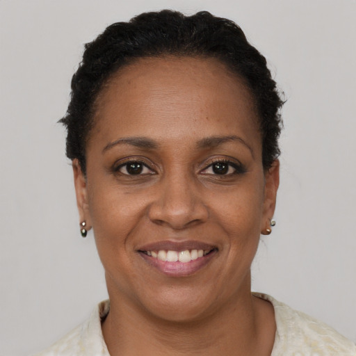 Joyful black adult female with short  brown hair and brown eyes