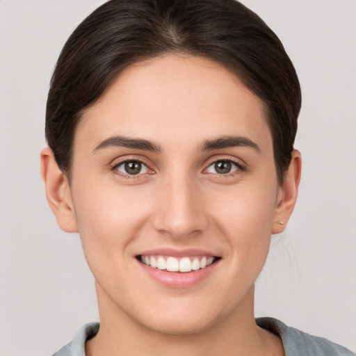 Joyful white young-adult female with short  brown hair and brown eyes