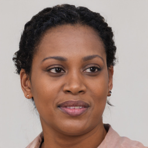 Joyful black young-adult female with short  black hair and brown eyes