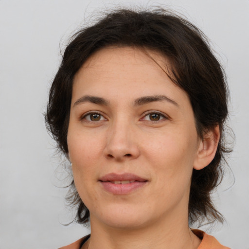 Joyful white adult female with medium  brown hair and brown eyes