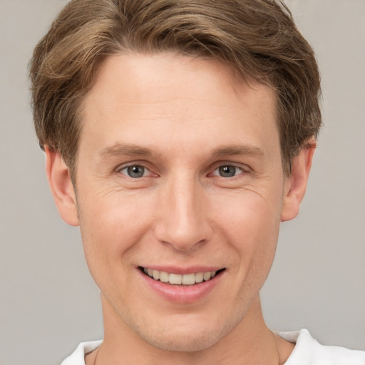 Joyful white adult male with short  brown hair and grey eyes