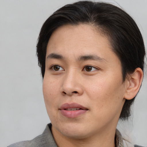 Joyful asian young-adult female with medium  brown hair and brown eyes
