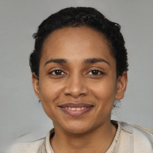 Joyful black young-adult female with short  black hair and brown eyes
