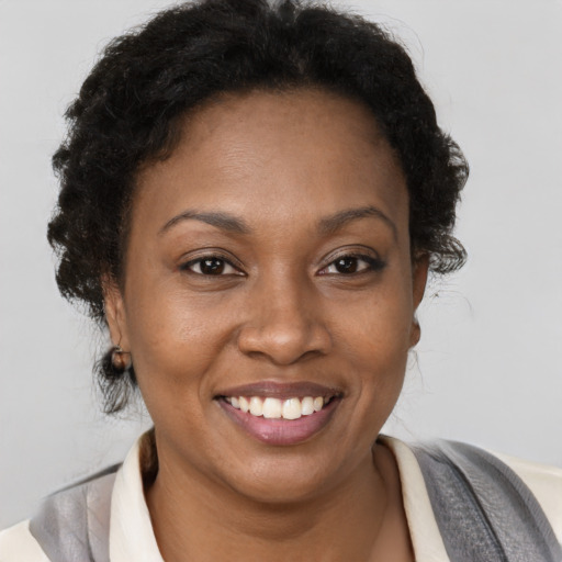 Joyful black young-adult female with short  brown hair and brown eyes