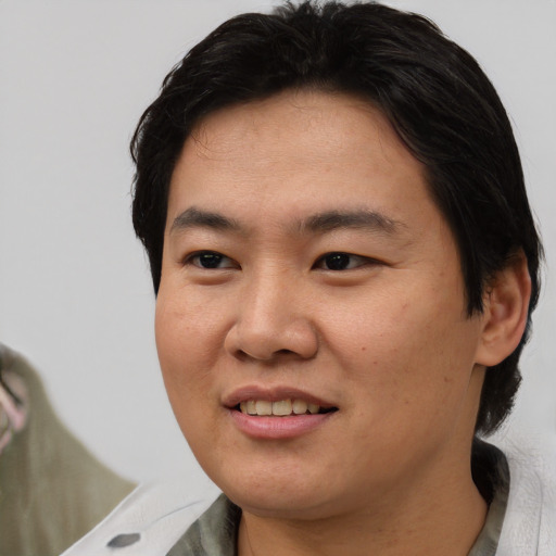 Joyful asian young-adult male with short  brown hair and brown eyes