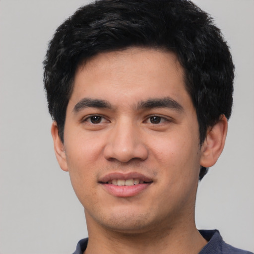 Joyful asian young-adult male with short  black hair and brown eyes