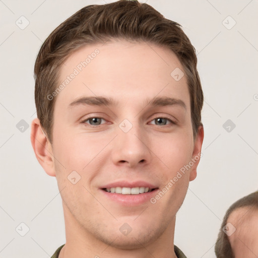 Joyful white young-adult male with short  brown hair and grey eyes