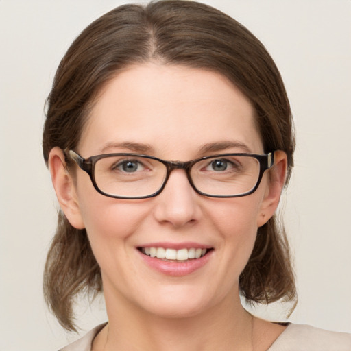 Joyful white young-adult female with medium  brown hair and green eyes