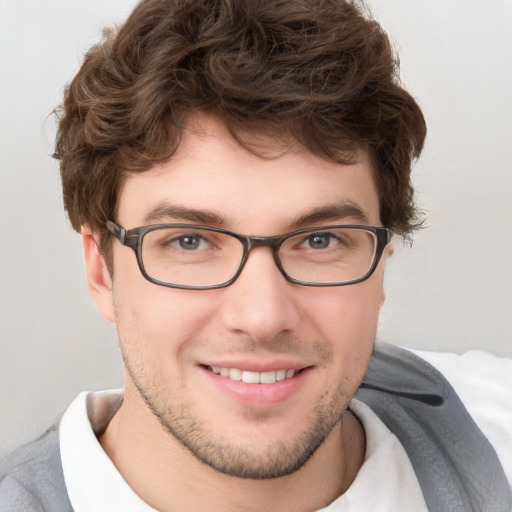 Joyful white young-adult male with short  brown hair and blue eyes