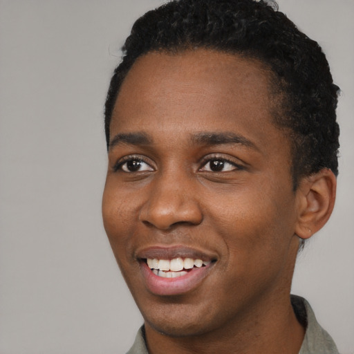 Joyful black young-adult male with short  black hair and brown eyes