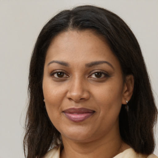 Joyful black adult female with long  brown hair and brown eyes