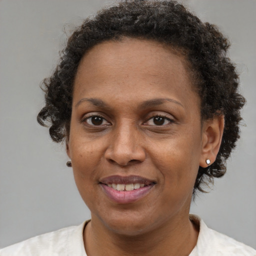 Joyful black adult female with short  brown hair and brown eyes