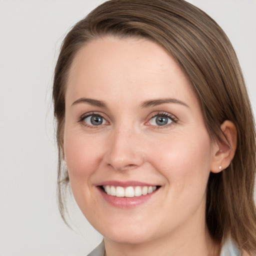 Joyful white young-adult female with medium  brown hair and grey eyes