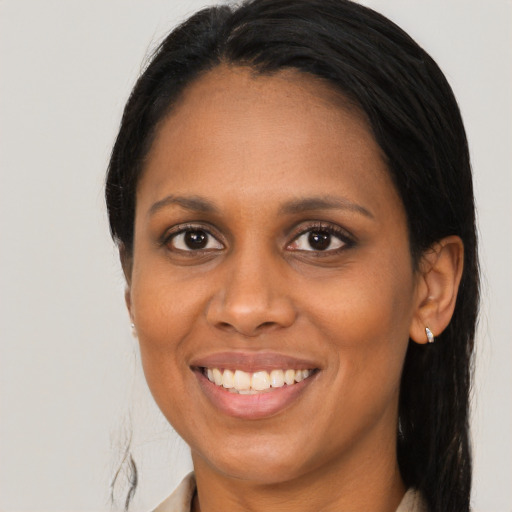 Joyful black adult female with long  brown hair and brown eyes