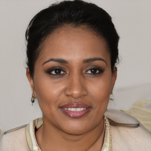 Joyful black young-adult female with short  brown hair and brown eyes