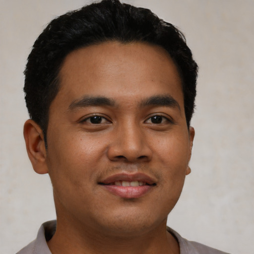Joyful latino young-adult male with short  black hair and brown eyes