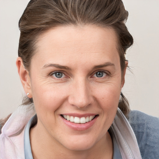 Joyful white young-adult female with medium  brown hair and grey eyes