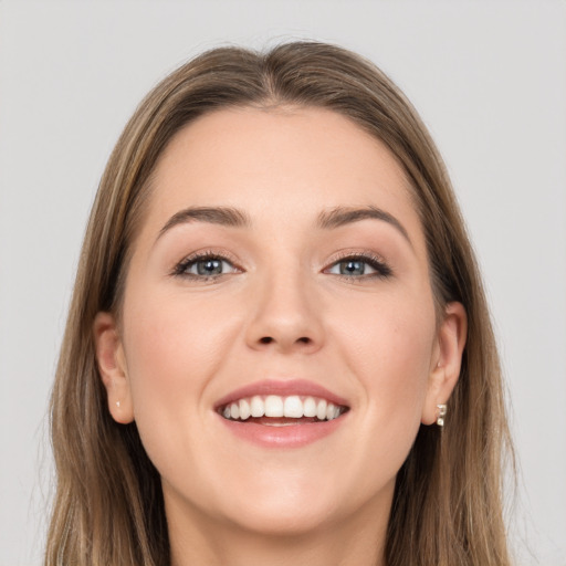 Joyful white young-adult female with long  brown hair and grey eyes