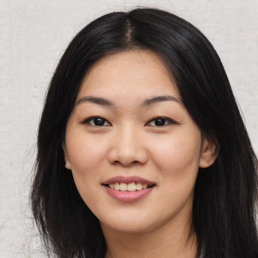Joyful asian young-adult female with long  black hair and brown eyes
