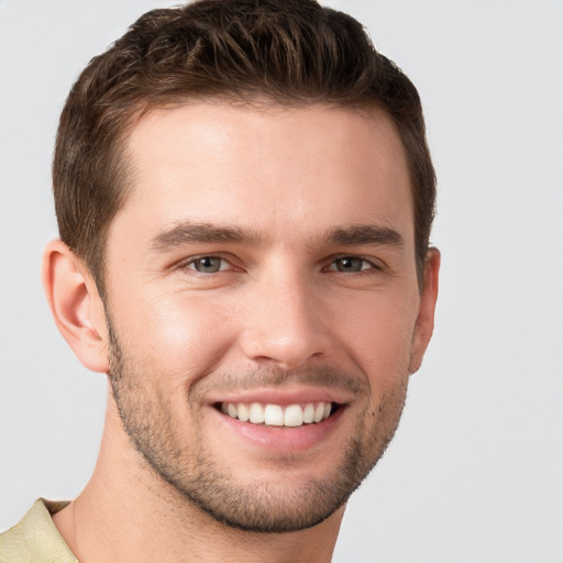 Joyful white young-adult male with short  brown hair and grey eyes