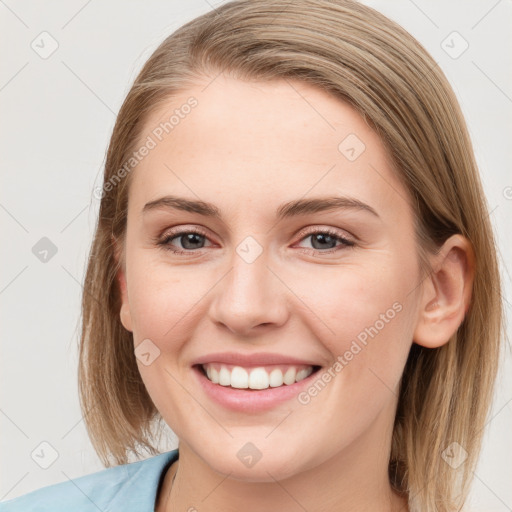 Joyful white young-adult female with medium  brown hair and blue eyes