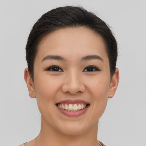 Joyful asian young-adult female with short  brown hair and brown eyes