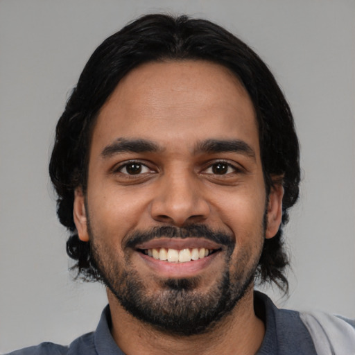 Joyful latino young-adult male with medium  black hair and brown eyes
