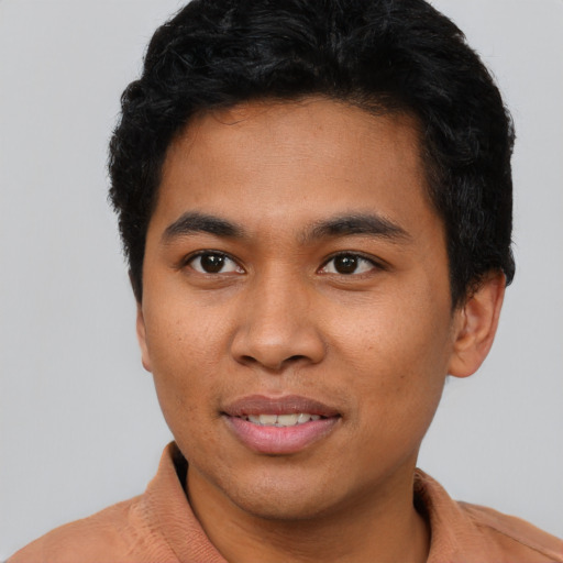 Joyful black young-adult male with short  brown hair and brown eyes
