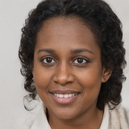 Joyful black young-adult female with long  brown hair and brown eyes