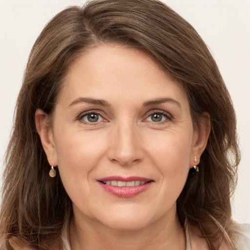 Joyful white adult female with long  brown hair and grey eyes