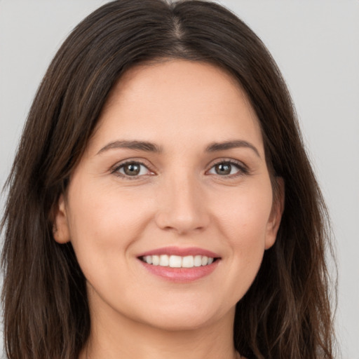 Joyful white young-adult female with long  brown hair and brown eyes