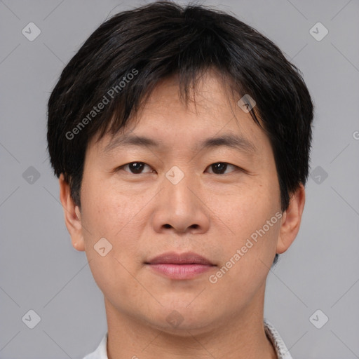 Joyful asian adult male with short  brown hair and brown eyes