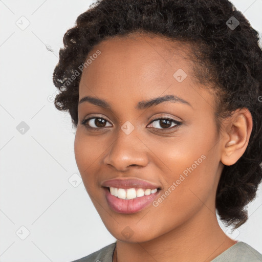 Joyful black young-adult female with long  brown hair and brown eyes