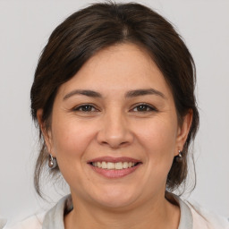 Joyful white adult female with medium  brown hair and brown eyes