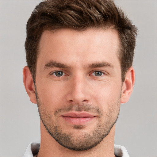 Joyful white young-adult male with short  brown hair and grey eyes