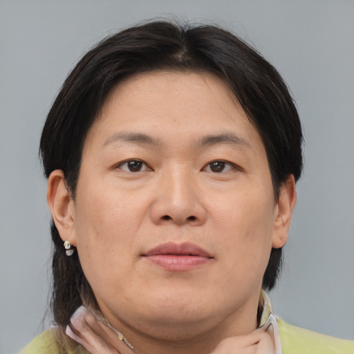 Joyful asian adult female with medium  brown hair and brown eyes