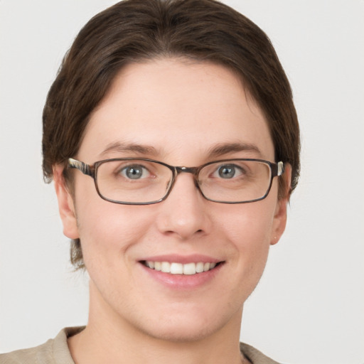 Joyful white young-adult female with short  brown hair and grey eyes