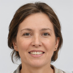 Joyful white adult female with medium  brown hair and grey eyes