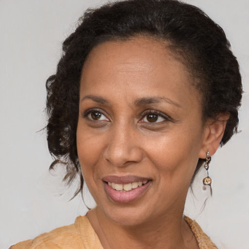 Joyful black adult female with medium  brown hair and brown eyes