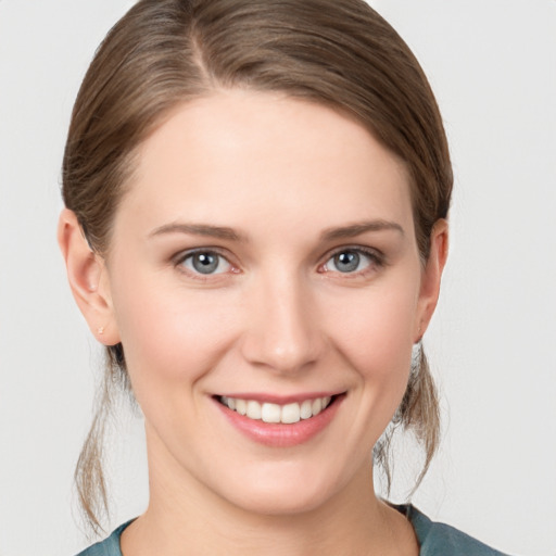 Joyful white young-adult female with medium  brown hair and grey eyes