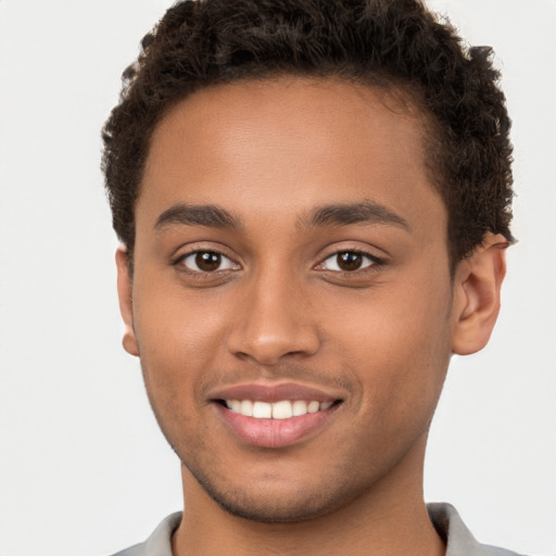 Joyful black young-adult male with short  brown hair and brown eyes