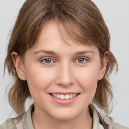 Joyful white young-adult female with medium  brown hair and grey eyes