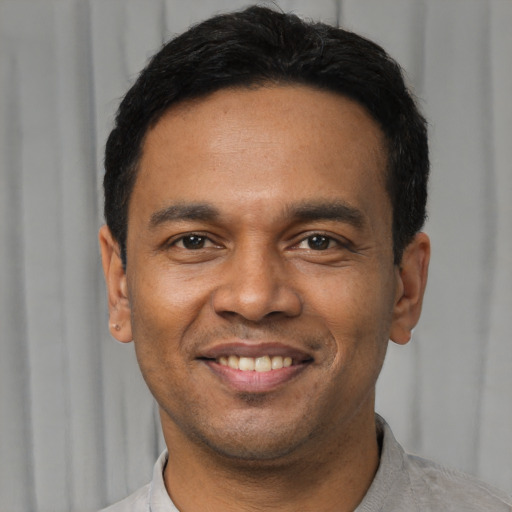 Joyful latino young-adult male with short  black hair and brown eyes