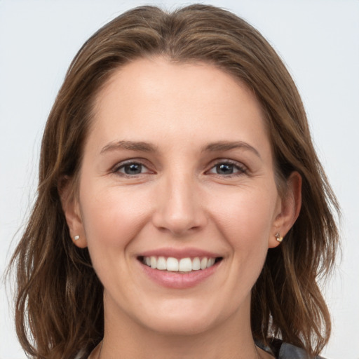 Joyful white young-adult female with long  brown hair and grey eyes