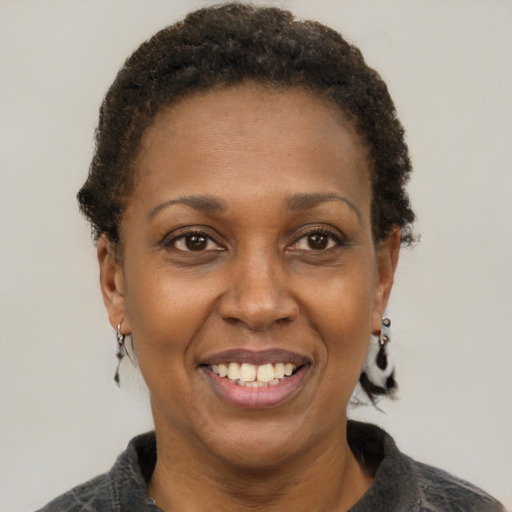 Joyful black adult female with short  brown hair and brown eyes