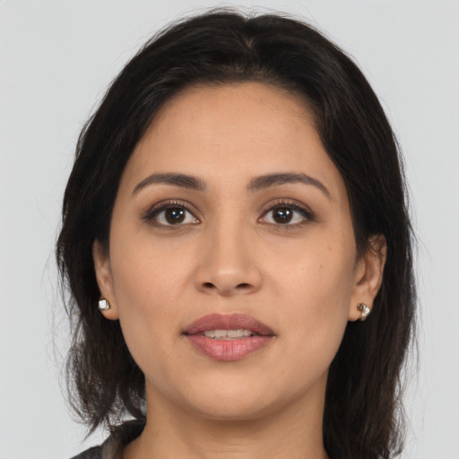 Joyful latino young-adult female with medium  brown hair and brown eyes